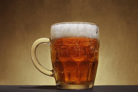 Téléchargez les photos : Mug with light beer and foam on brown background - en image libre de droit