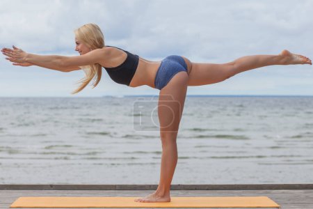 Téléchargez les photos : Young beauty athletic woman in a swimsuit on the beach - en image libre de droit