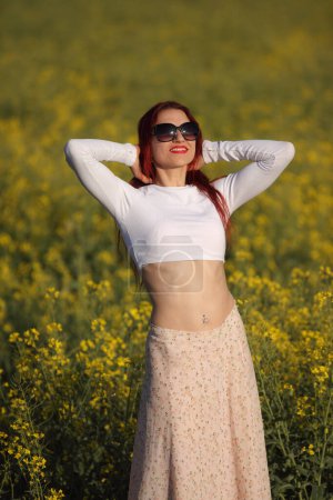 Téléchargez les photos : Jeune femme de beauté dans un champ avec du colza - en image libre de droit