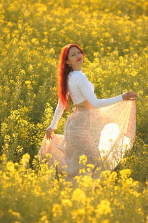 Foto de Joven belleza mujer en un campo con colza - Imagen libre de derechos