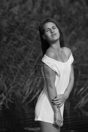 Photo for Young woman in a white T-shirt on the river - Royalty Free Image