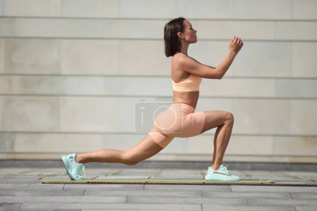 Photo for Beautiful young woman in sportswear exercising outdoors - Royalty Free Image