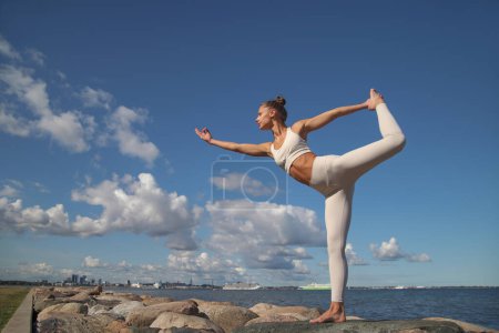 Photo for Young beauty athletic woman practicing yoga on the beach - Royalty Free Image