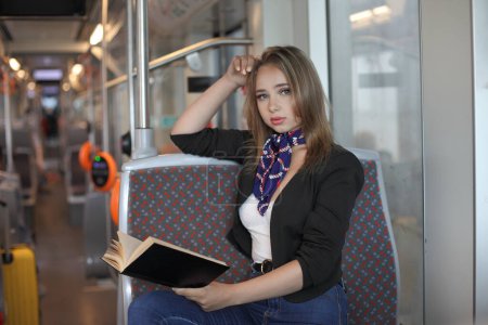 Foto de Hermosa joven en tranvía leyendo su libro - Imagen libre de derechos