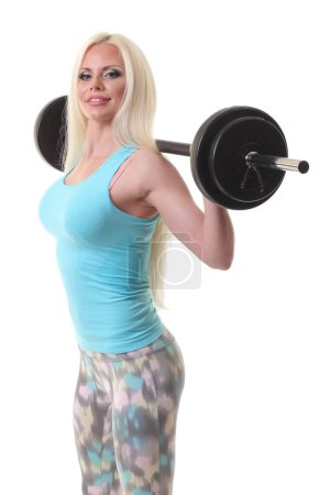 Photo for Smiling sporty woman exercising with barbell on a white background - Royalty Free Image