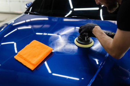Sealant car polishing with orbital polisher for remove scratches. Worker of detailing auto service making final polishing for car