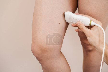 Photo for Legs ultrasound examination scan using portable ultrasound machine. Vascular surgeon examines veins and arteries of legs of woman in medical clinic - Royalty Free Image