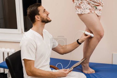 Photo for Vascular surgeon examines veins and arteries of legs of girl in medical clinic. Legs ultrasound examination scan for woman - Royalty Free Image