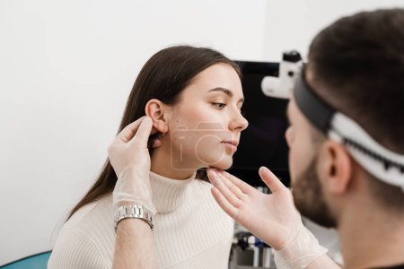 Photo for Otoplasty surgical reshaping of pinna and ear. Otoplasty ear surgery. Surgeon doctor examines girl ears before otoplasty cosmetic surgery - Royalty Free Image