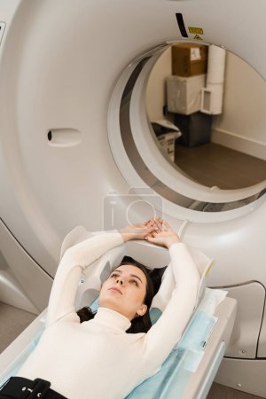 Foto de CT scan of abdomen of woman in medical clinic. Girl patient is doing CT computed tomography x-ray scan of chest for examination of abdomen in a CT scanning room - Imagen libre de derechos