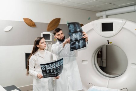 Foto de Two doctors discussing x-rays after CT scan of patient abdomen. CT Computed tomography scan procedure to obtain detailed internal images of body and research on tumors in head, brain, and spine - Imagen libre de derechos