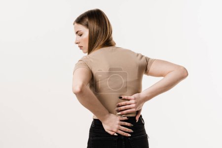 Foto de Attractive girl feel spine pain because of spinal nerves compression. Cervical spine osteochondrosis is radicular syndromes of young woman - Imagen libre de derechos