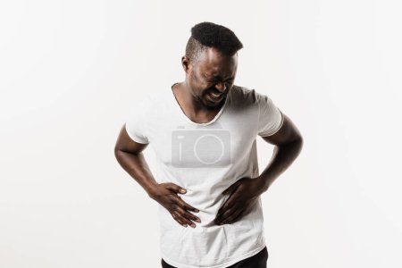 Photo for Cancer of stomach and esophagus of African man. Sick african american man is holding his stomach because it hurts. Pancreatitis disease of pancreas becomes inflamed - Royalty Free Image