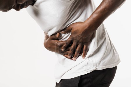 Photo for Appendicitis is inflammation of appendix. African american man feel abdominal pain, fever, vomiting, and loss of appetite because of appendicitis inflammation - Royalty Free Image
