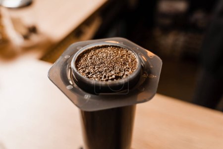 Close-up gemahlener Kaffee mit heißem Wasser in der Aeropress. Prozess der Aeropress alternative Methode Kaffee brauen. Heißes Wasser über geröstete und gemahlene Kaffeebohnen in der Aeropress gießen