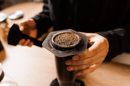 Photo for Close-up ground coffee with hot water in aeropress. Process of aeropress alternative method brewing coffee. Pouring hot water over roasted and ground coffee beans in aeropress - Royalty Free Image