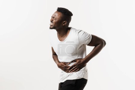 Photo for Sick african american man hold abdomen because it hurts. Stomach pain. Pancreatitis disease of pancreas becomes inflamed - Royalty Free Image