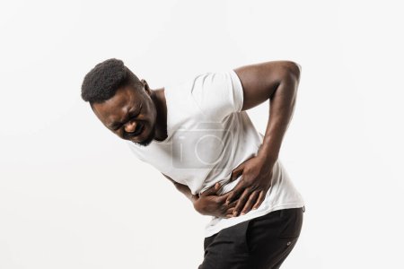 Photo for Appendicitis is inflammation of appendix. African american man feel abdominal pain, fever, vomiting, and loss of appetite because of appendicitis inflammation - Royalty Free Image