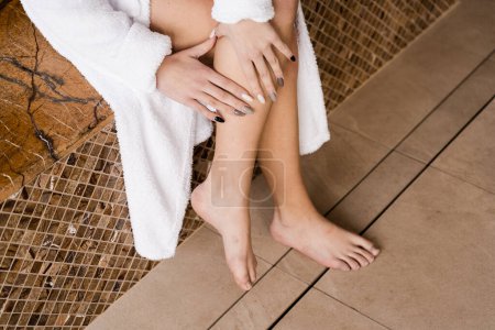 Photo for Deep vein thrombosis and varicose of woman. Girl touching her legs and looking at veins. Sclerotherapy procedure at visiting vascular surgeon doctor - Royalty Free Image