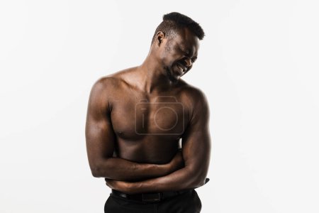 Photo for Ulcer or gastritis stomach ache. Sick muscular african american man hold abdomen because it hurts. Pancreatitis disease of pancreas becomes inflamed - Royalty Free Image