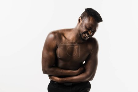 Photo for Stomach pain. Pancreatitis disease of pancreas becomes inflamed. Sick muscular african american man hold abdomen because it hurts - Royalty Free Image