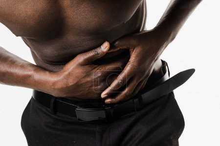 Photo for Appendicitis is inflammation of appendix close-up. Muscular shirtless african american man feel abdominal pain, fever, vomiting, and loss of appetite because of appendicitis inflammation - Royalty Free Image