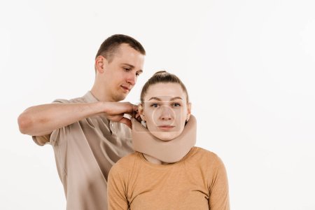 Téléchargez les photos : Neurochirurgien met bandage du cou sur la fille pour stabiliser la région cervicale en cas de douleur au cou, blessures et entorses sur fond blanc - en image libre de droit