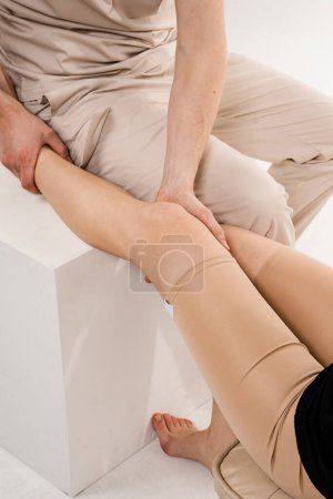 Photo for Knee joint and meniscus injury. Orthopedist is touching and pressing knee for assessment of the volume of physiological movements. Examination of knee mobilisations - Royalty Free Image