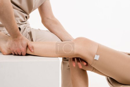 Photo for Knee joint and meniscus injury. Orthopedist is touching and pressing knee for assessment of the volume of physiological movements. Examination of knee mobilisations - Royalty Free Image