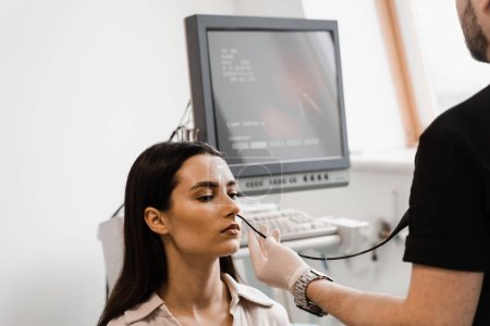 ENT doctor using fibrolaryngoscope to examine and treat nose. ENT specialist diagnoses and treats larynx and pharynx, such as hoarseness, vocal cord nodules, tumors, infections, and inflammation