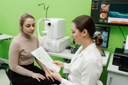 Foto de Consulta con optometrista con tomografía de coherencia óptica OCT scan para crear imágenes de la parte posterior del ojo. Examen de los ojos del paciente mediante tomógrafo de coherencia óptica - Imagen libre de derechos