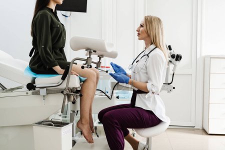 Gynecologist does colposcopy procedure to closely examine cervix, vagina and vulva of girl in gynecology clinic. Gynecologist is looking in colposcope for detail examination of disease