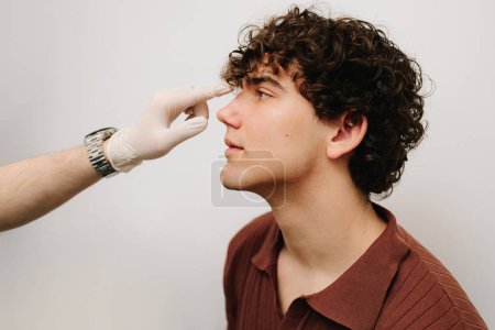 Examen del tabique nasal para determinar el problema del paciente. Proceso de consulta de un médico otorrinolaringólogo. Consultar al paciente antes de la rinoplastia