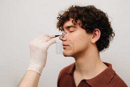 Prozess der Erstellung eines Markups auf der männlichen Nase vor der Nasenkorrektur und Septoplastik-Operation. HNO-Arzt bereitet Patienten auf Nasenkorrektur vor, die die Form der Nase verändert