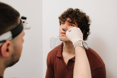 ORL médecin vérifiant nez du patient avec rhinoscope. Examen médical de rhinoscopie dans une clinique ORL privée avant la chirurgie de rhinoplastie ou de septoplastie