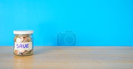 Téléchargez les photos : Argent en pot avec des pièces sur table en bois - en image libre de droit