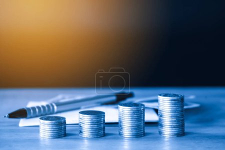 Photo for Stack of coins and coin on wooden table - Royalty Free Image