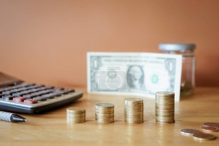 Foto de Concepto empresarial y financiero: monedas, calculadora, bolígrafo y dinero sobre la mesa - Imagen libre de derechos