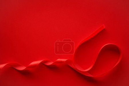 Photo for Red satin ribbon on a red background - Royalty Free Image