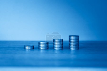 Foto de Pila de monedas sobre fondo azul con espacio de copia. concepto financiero - Imagen libre de derechos