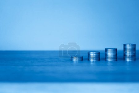 Foto de Monedas en frasco de vidrio azul con fondo azul - Imagen libre de derechos
