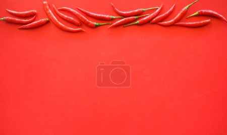 Foto de Chiles rojos sobre fondo rojo. - Imagen libre de derechos