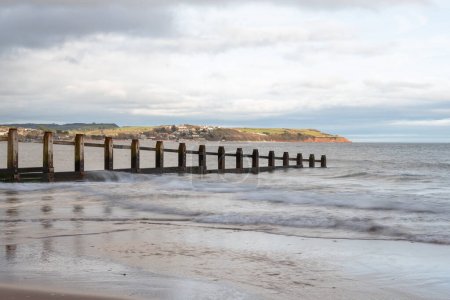 Photo for Landscape photo of a groyne in the sea at Dawlish Warren nature reserve with Exmouth in the background - Royalty Free Image