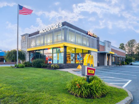 Téléchargez les photos : Whitesboro, New York - 9 août 2023 : Paysage Vue rapprochée de l'extérieur du McDonald's Building avec le drapeau américain devant. - en image libre de droit