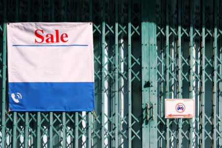 Téléchargez les photos : Signe de vente de bâtiment commercial sur porte pliante. - en image libre de droit