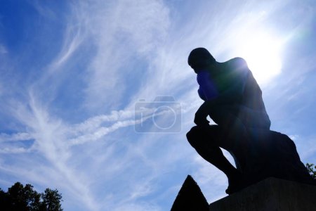 Foto de Estatua del Pensador Silueta con Fare Light y Blue Sky Antecedentes frente al Museo Rodin, París Francia. - Imagen libre de derechos