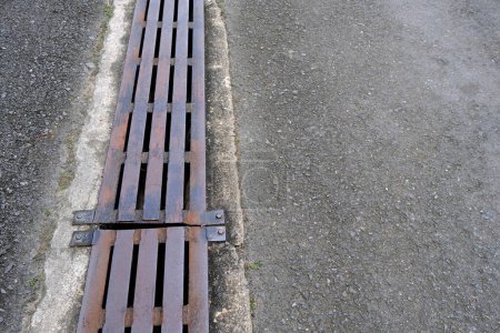 Photo for Water Drain with Metal Cover on the Asphalt Road. - Royalty Free Image