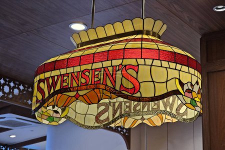 Photo for BANGKOK, THAILAND - OCTOBER 13, 2023: Vintage Stained Glass Ceiling Light with Swensens Name on the Lamp. Swensens was started in 1948 by Earle Swensen. - Royalty Free Image