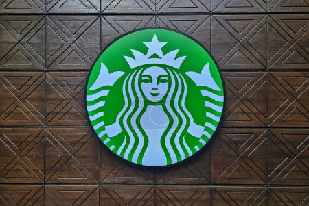 Téléchargez les photos : BANGKOK, THAÏLANDE - 13 OCTOBRE 2023 : Panneau Starbucks sur mur en bois vintage. Starbucks est une chaîne de café multinationale américaine fondée en 1971. - en image libre de droit