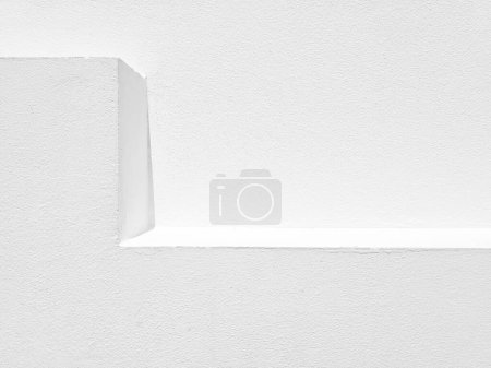 Téléchargez les photos : Étagère et mur en stuc blanc avec lumière naturelle et arrière-plan ombragé. - en image libre de droit